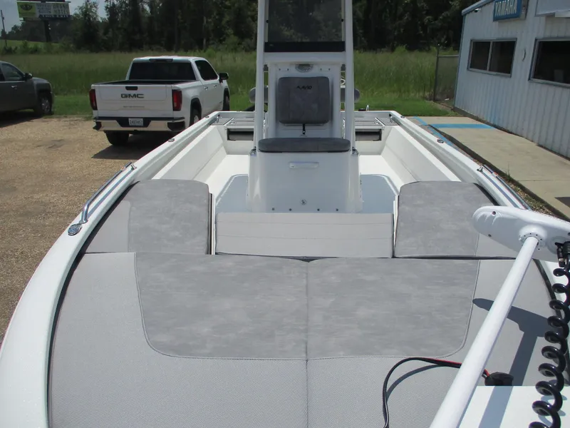 Slide: The Image of 2025 Avid 23 Fusion boat with spacious deck and seating, parked outdoors. - 2