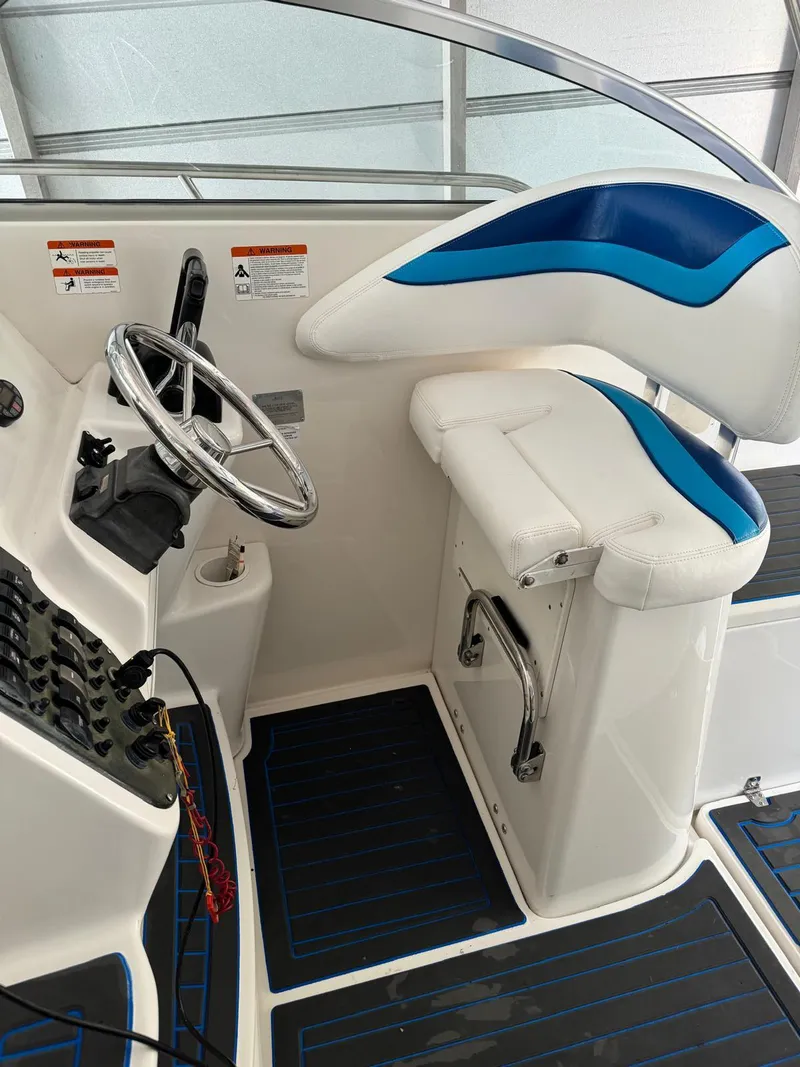 Slide: The Image of 2005 Seaswirl Striper 2901 Walkaround O/B helm with steering wheel and cushioned seat. - 10