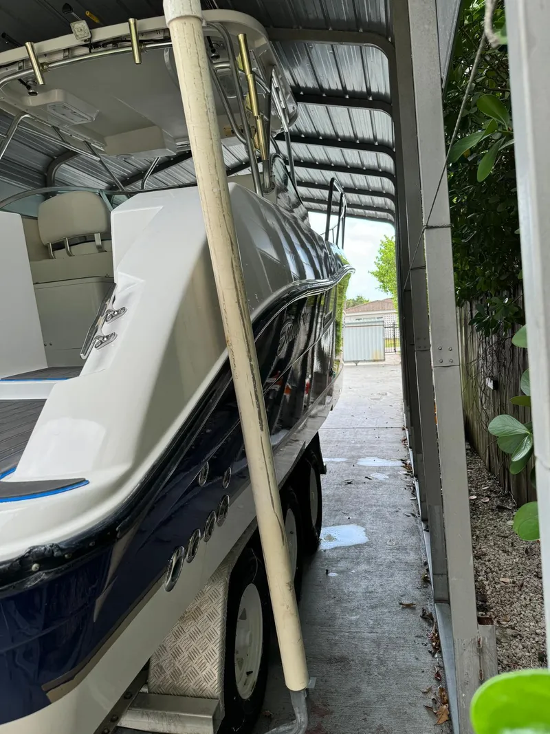 Slide: The Image of 2005 Seaswirl Striper 2901 Walkaround O/B boat parked under a metal canopy. - 21