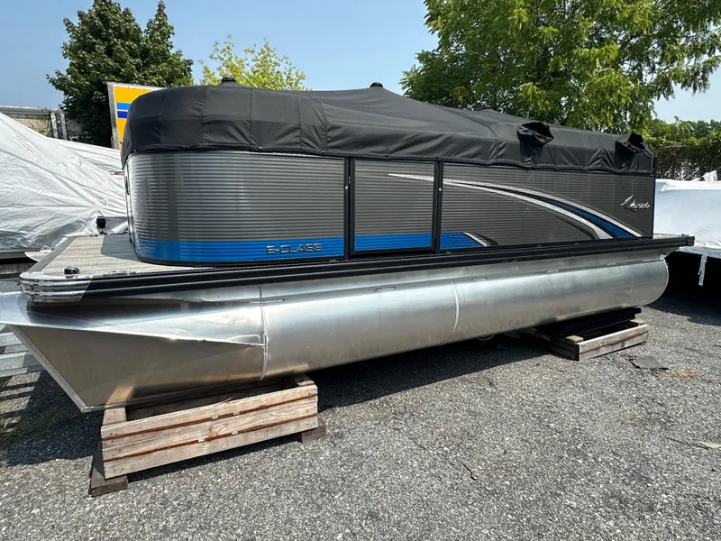 The Image of 2024 Qwest E 816 RLS LT pontoon boat with cover, parked on wooden blocks. - 0