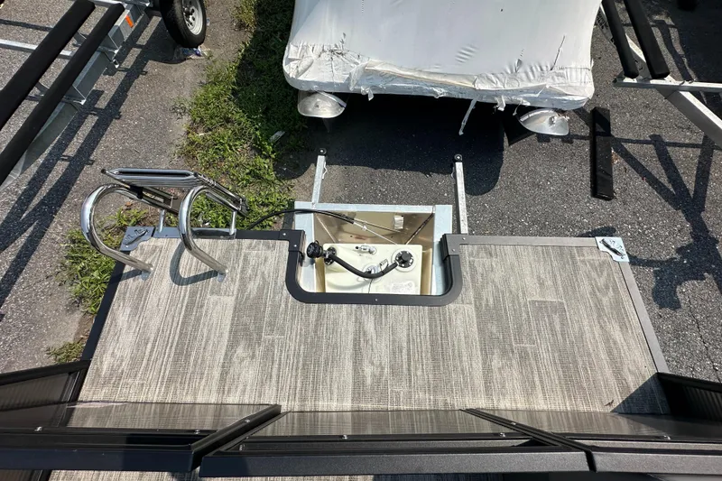 Slide: The Image of 2024 Qwest E 816 RLS LT boat deck with ladder and covered trailer. - 8