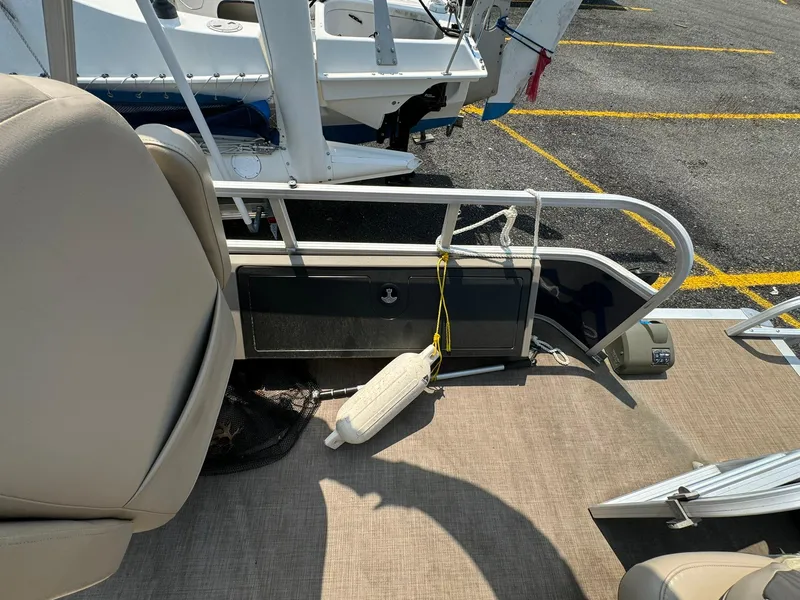 Slide: The Image of 2020 Tracker FISHIN 22 BARGE DLX pontoon boat interior with beige seating and safety rail. - 10