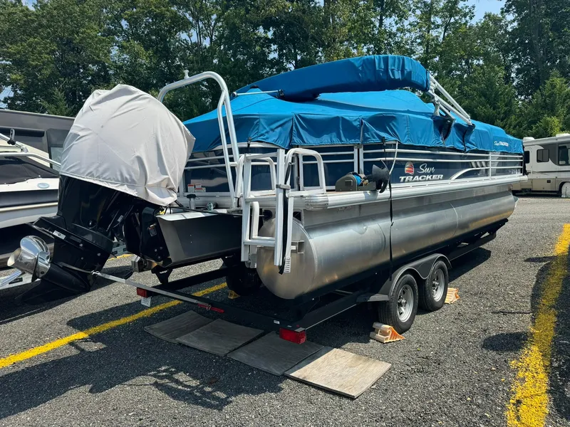 Slide: The Image of 2020 Tracker FISHIN 22 BARGE DLX pontoon boat with blue cover on trailer. - 13