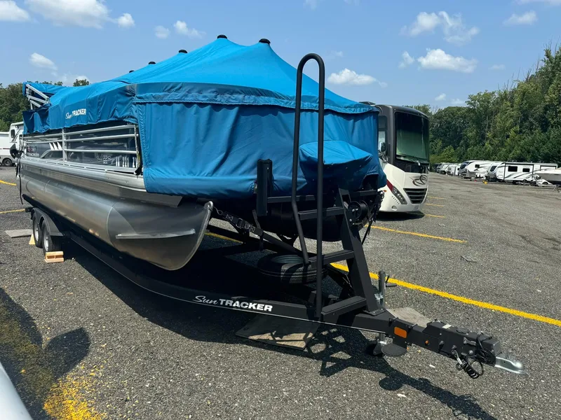 Slide: The Image of 2020 Tracker FISHIN 22 BARGE DLX pontoon boat with blue cover on trailer. - 15