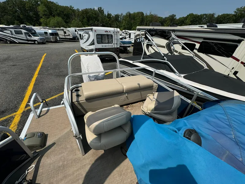 Slide: The Image of 2020 Tracker FISHIN 22 BARGE DLX pontoon boat in a parking lot with RVs. - 7