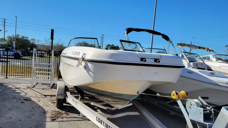 Slide: The Image of 2020 Bayliner DX2200 PROJECT boat on trailer in sunny outdoor setting. - 1