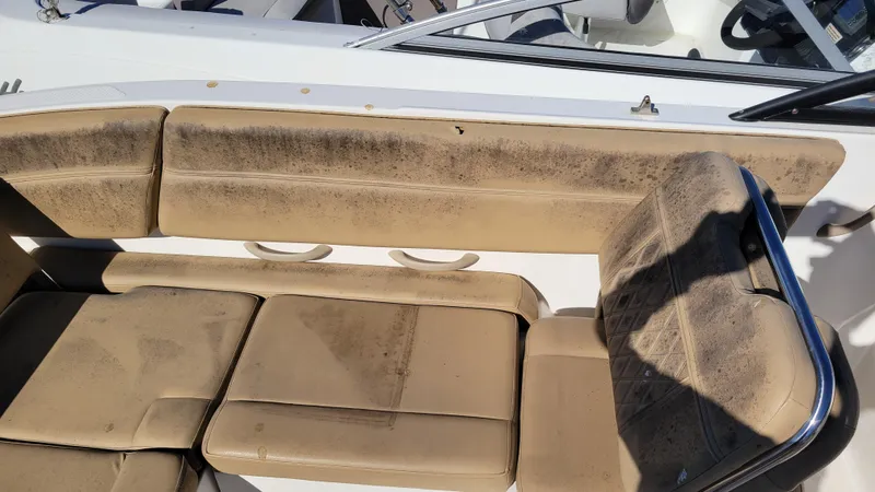 Slide: The Image of Bayliner DX2200 PROJECT 2020 boat with worn beige seating and cup holders. - 11