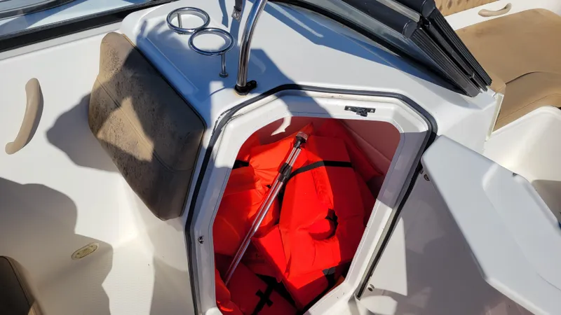 Slide: The Image of Bayliner DX2200 PROJECT 2020 boat interior with storage compartment and life jacket. - 12