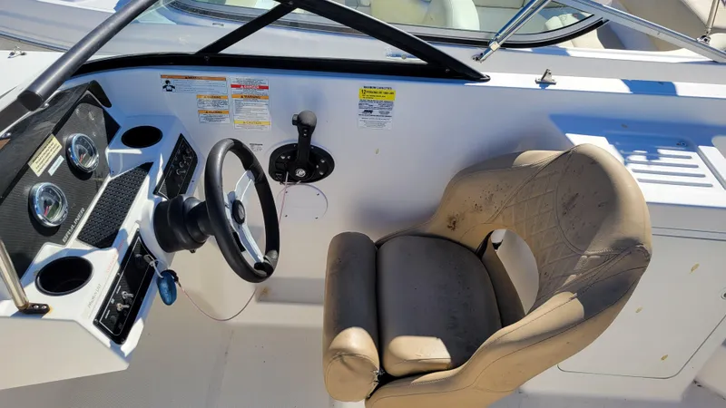 Slide: The Image of 2020 Bayliner DX2200 PROJECT boat cockpit with steering wheel and beige captain's chair. - 16