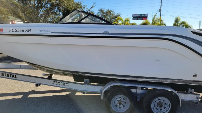 Slide: The Image of 2020 Bayliner DX2200 boat on trailer, parked outdoors. - 6
