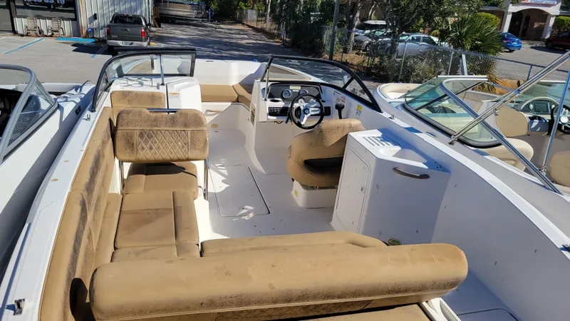 Slide: The Image of 2020 Bayliner DX2200 PROJECT boat interior with beige seating and steering wheel. - 8