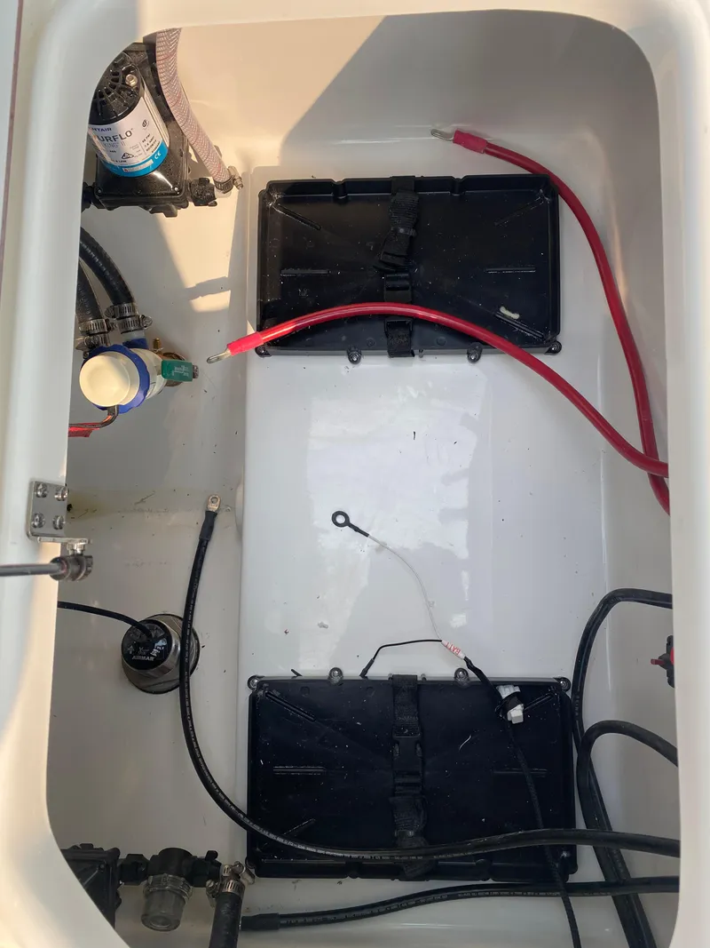 Slide: The Image of 2024 Sea Pro 242 Center Console battery compartment with wiring and components. - 17