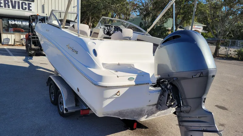 Slide: The Image of 2019 Hurricane SUNDECK 217 PROJECT boat on trailer, featuring outboard motor. - 5