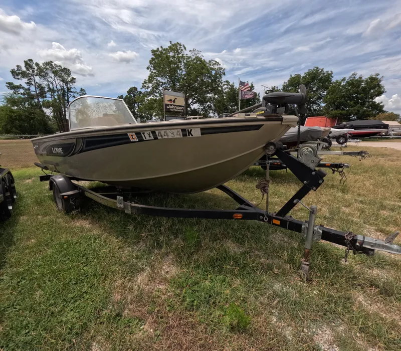 The Image of 2005 Lowe Fish & Ski FS175 boat on trailer, parked on grass under cloudy sky. - 0