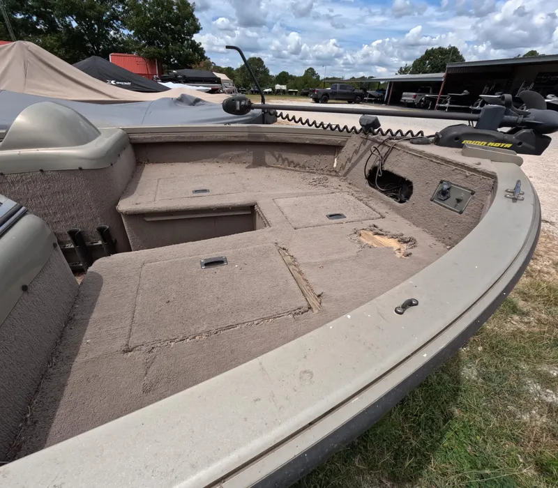 Slide: The Image of 2005 Lowe Fish & Ski FS175 boat interior with worn carpet and storage compartments. - 7