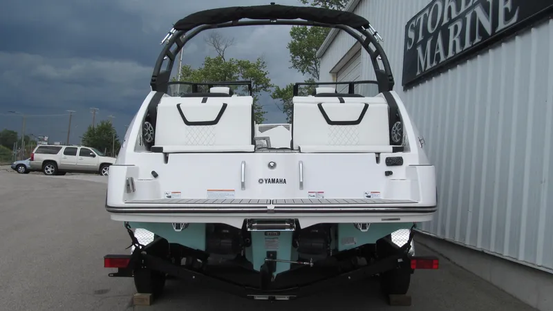 Slide: The Image of 2025 Yamaha Boats 222S, rear view, parked at a marina with overcast skies. - 3