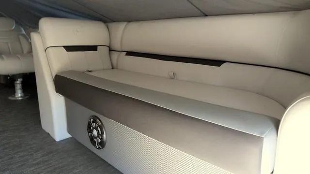 Slide: The Image of 2024 Godfrey Pontoons Sweetwater 2286 SFL interior seating with speaker, beige upholstery. - 2