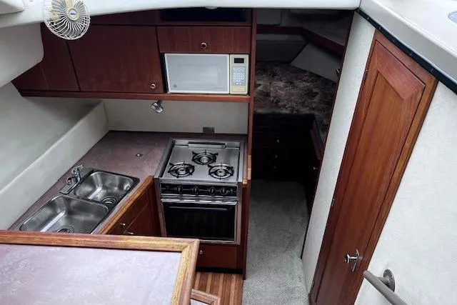 Slide: The Image of 1996 Bayliner 3388 Command Bridge Motoryacht interior kitchen with stove, sink, and microwave. - 21