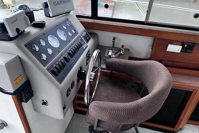 Slide: The Image of 1996 Bayliner 3388 Command Bridge Motoryacht helm with Garmin navigation and plush captain's chair. - 27