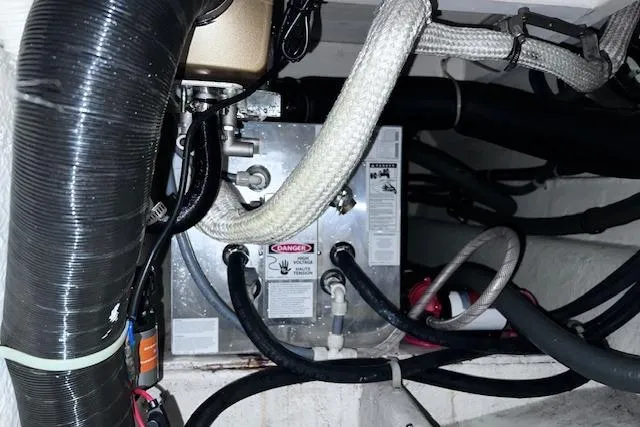 Slide: The Image of Engine compartment of a 1996 Bayliner 3388 Command Bridge Motoryacht with visible hoses and wiring. - 30