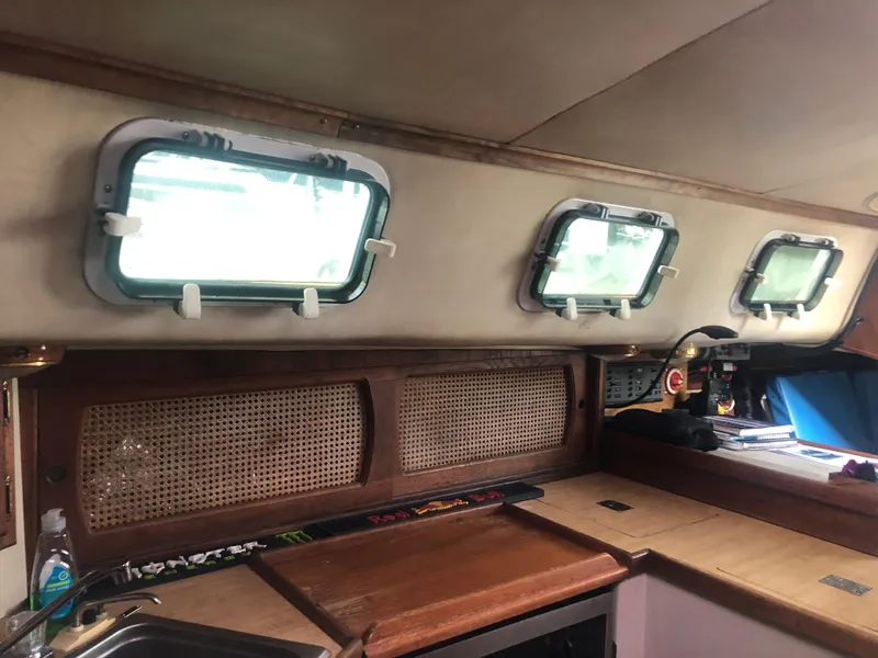Slide: The Image of Interior of 1980 Lancer 36 sailboat with wooden cabinetry and porthole windows. - 25