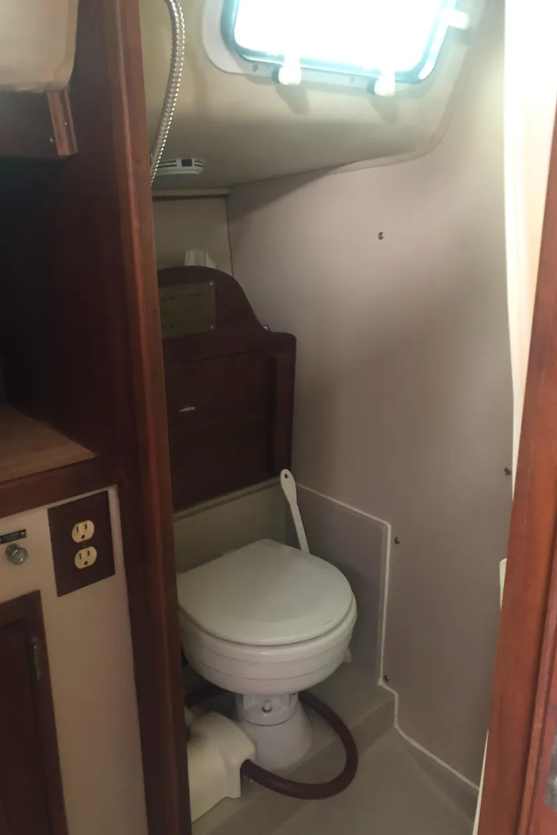 Slide: The Image of 1980 Lancer 36 yacht bathroom with compact toilet and wooden cabinetry. - 34