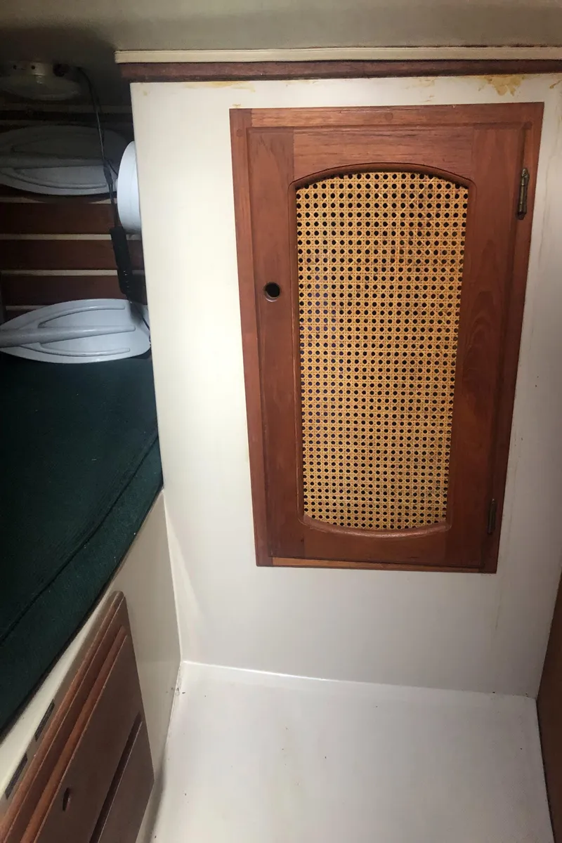 Slide: The Image of 1980 Lancer 36 interior with wooden cabinet and green cushioned seating. - 39