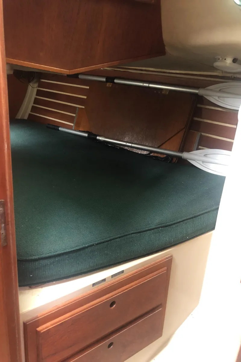 Slide: The Image of 1980 Lancer 36 yacht interior with wooden cabinets and green cushioned bed. - 42