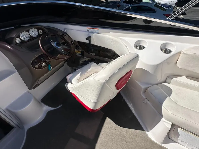 Slide: The Image of Interior of a 2006 Regal 2450 Cuddy boat, featuring steering console and seating. - 15