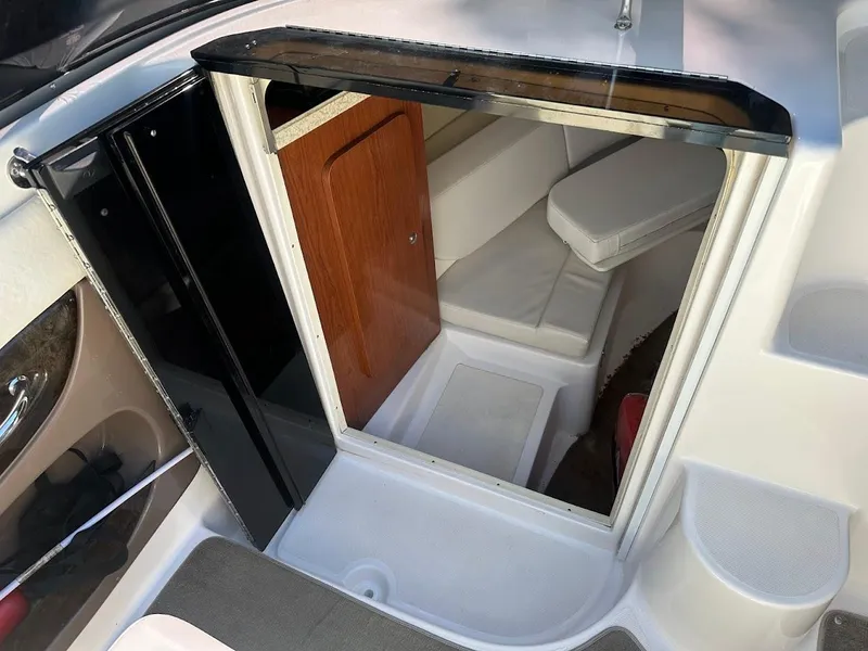 Slide: The Image of 2006 Regal 2450 Cuddy cabin interior with seating and wooden door. - 22