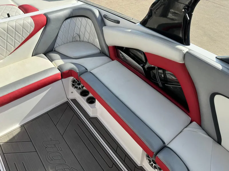 Slide: The Image of 2016 Tigé RZ2 boat interior with red and gray seating, cup holders, and stylish design. - 10