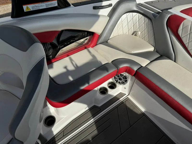 Slide: The Image of 2016 Tigé RZ2 boat interior with red and gray seating, cup holders, and quilted accents. - 12