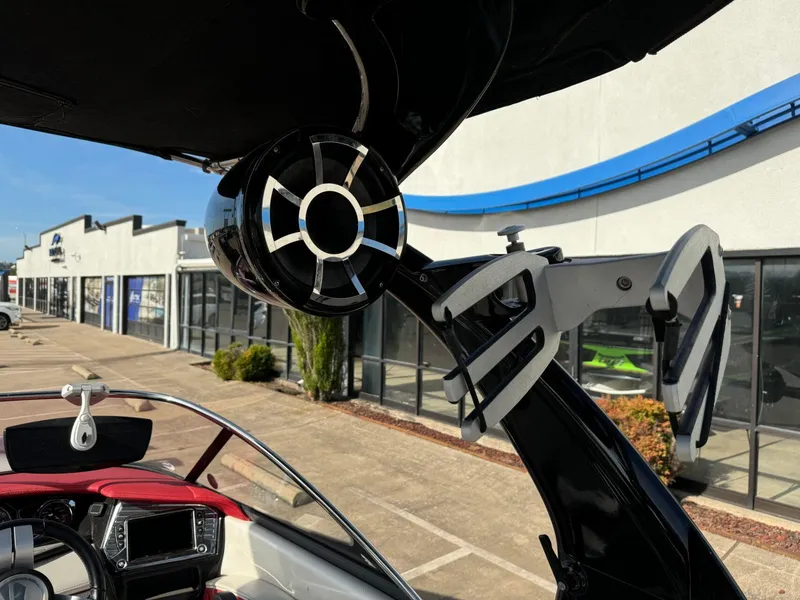 Slide: The Image of 2016 Tigé RZ2 boat with speaker and wakeboard rack, parked near a dealership. - 14