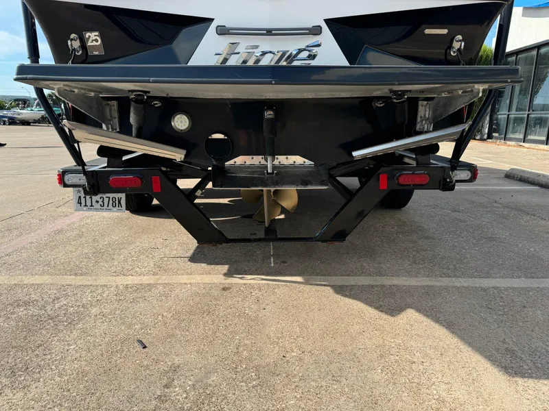 Slide: The Image of Rear view of a 2016 Tigé RZ2 boat on a trailer in a parking lot. - 2