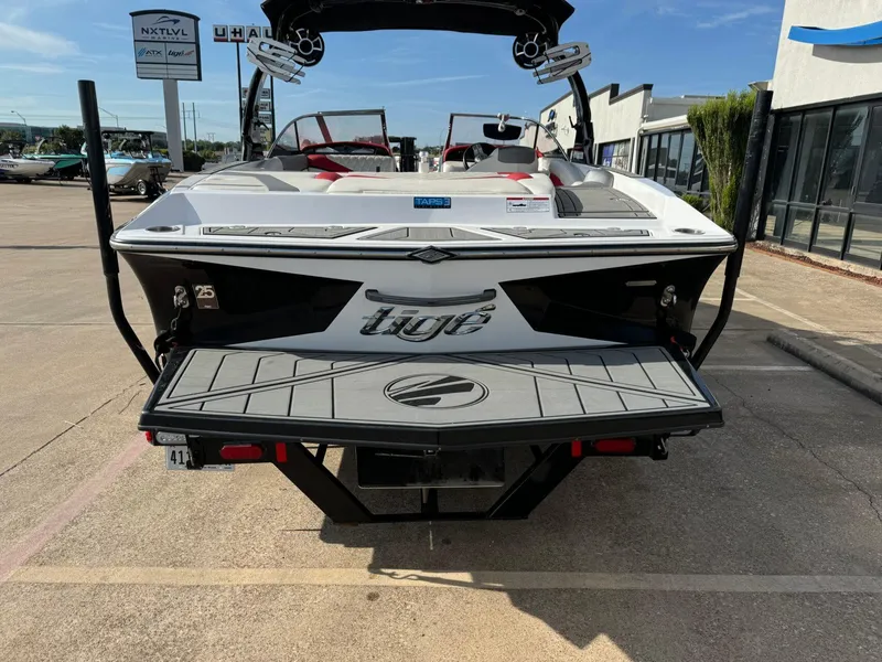 Slide: The Image of 2016 Tigé RZ2 boat rear view in a parking lot, showcasing sleek design and branding. - 4