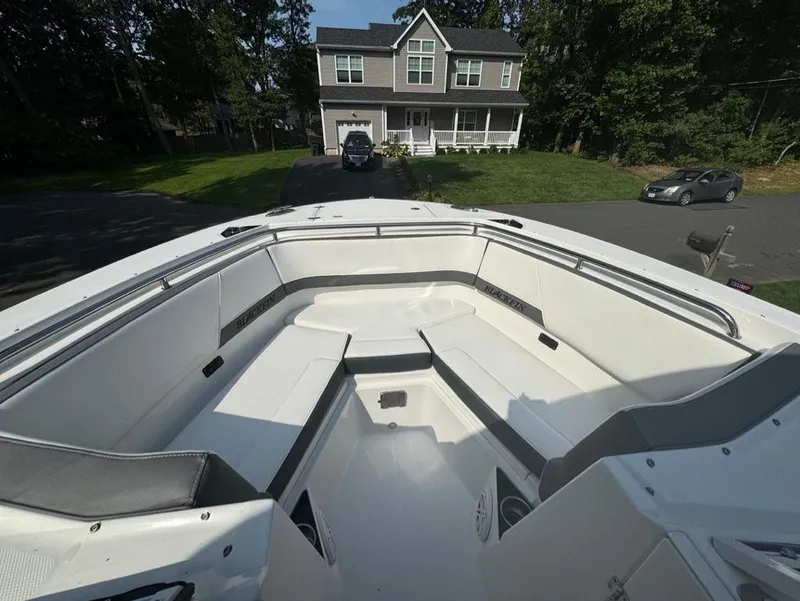 Slide: The Image of 2020 Blackfin 272 DC boat with spacious seating, parked in front of a suburban house. - 15