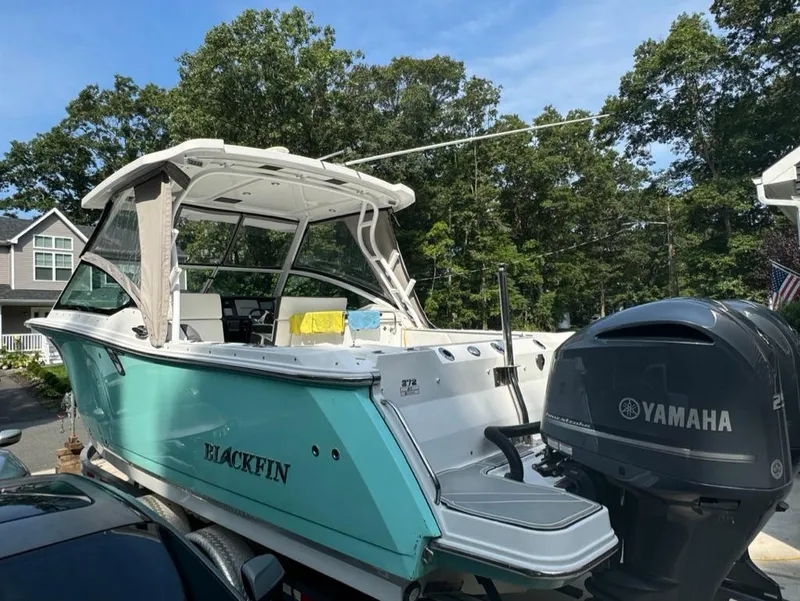 Slide: The Image of 2020 Blackfin 272 DC boat with Yamaha engine, parked outdoors. - 2