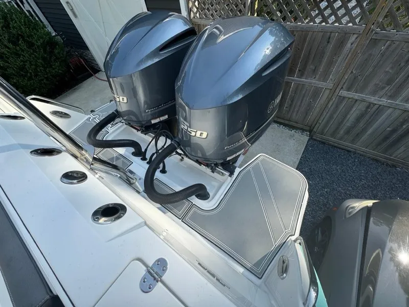 Slide: The Image of Twin outboard engines on a 2020 Blackfin 272 DC boat, docked near a wooden fence. - 26