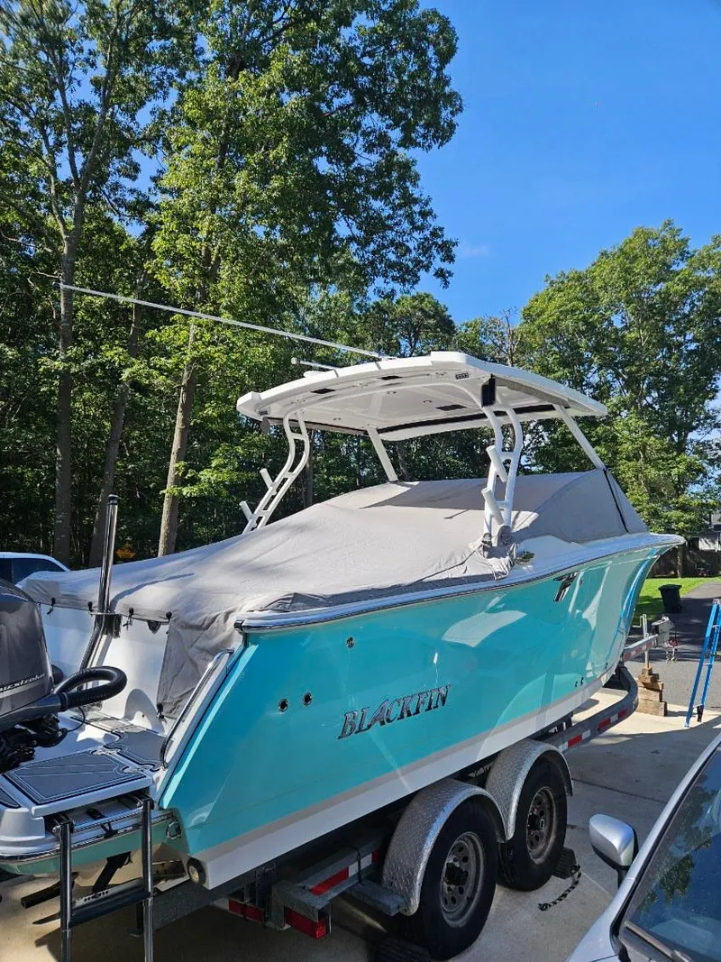 Slide: The Image of 2020 Blackfin 272 DC boat on trailer, covered, surrounded by trees. - 5