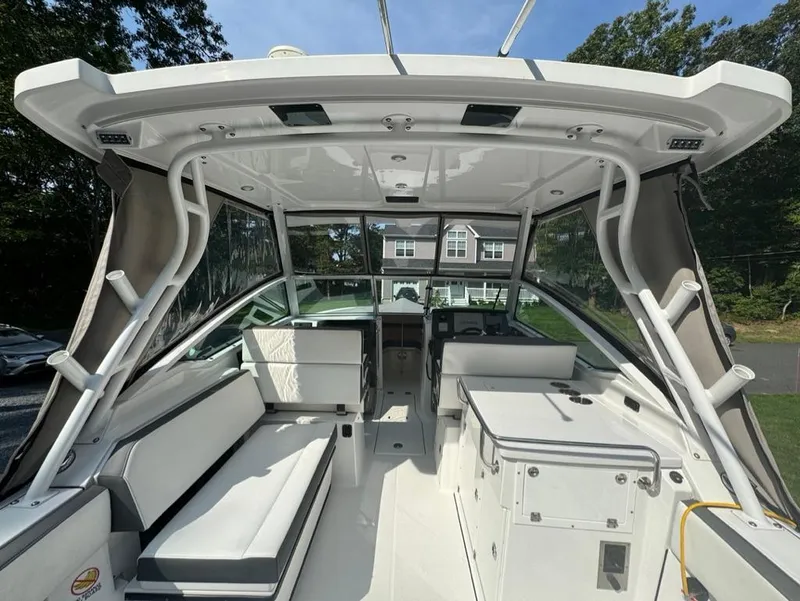 Slide: The Image of 2020 Blackfin 272 DC boat interior with seating and helm, docked outdoors. - 7