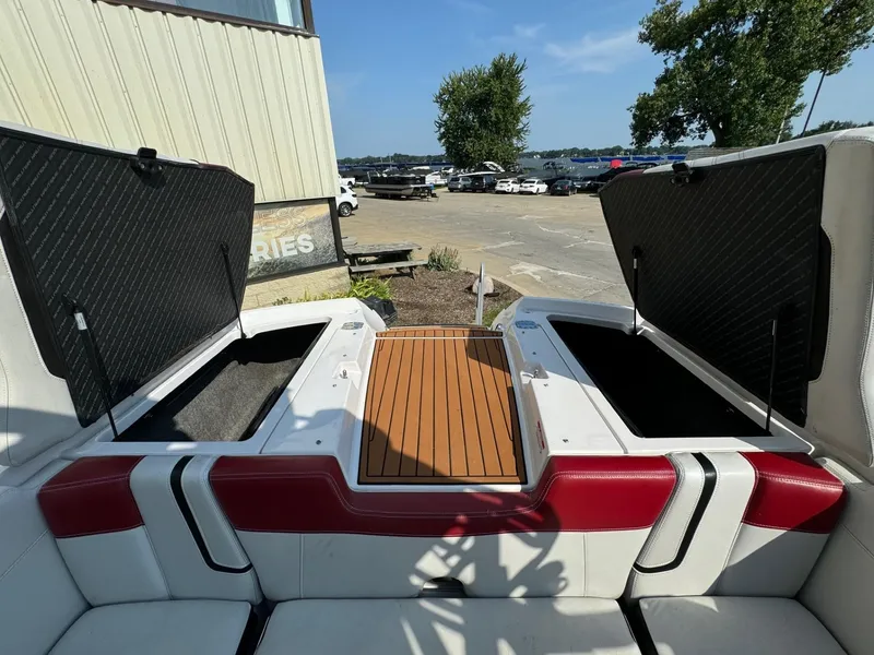 Slide: The Image of 2014 Nautique G23 boat interior with open storage compartments and wooden deck. - 11