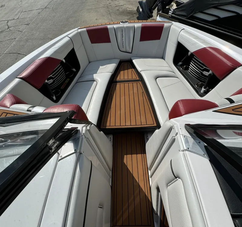 Slide: The Image of 2014 Nautique G23 boat interior with white and red seating, wooden flooring. - 12