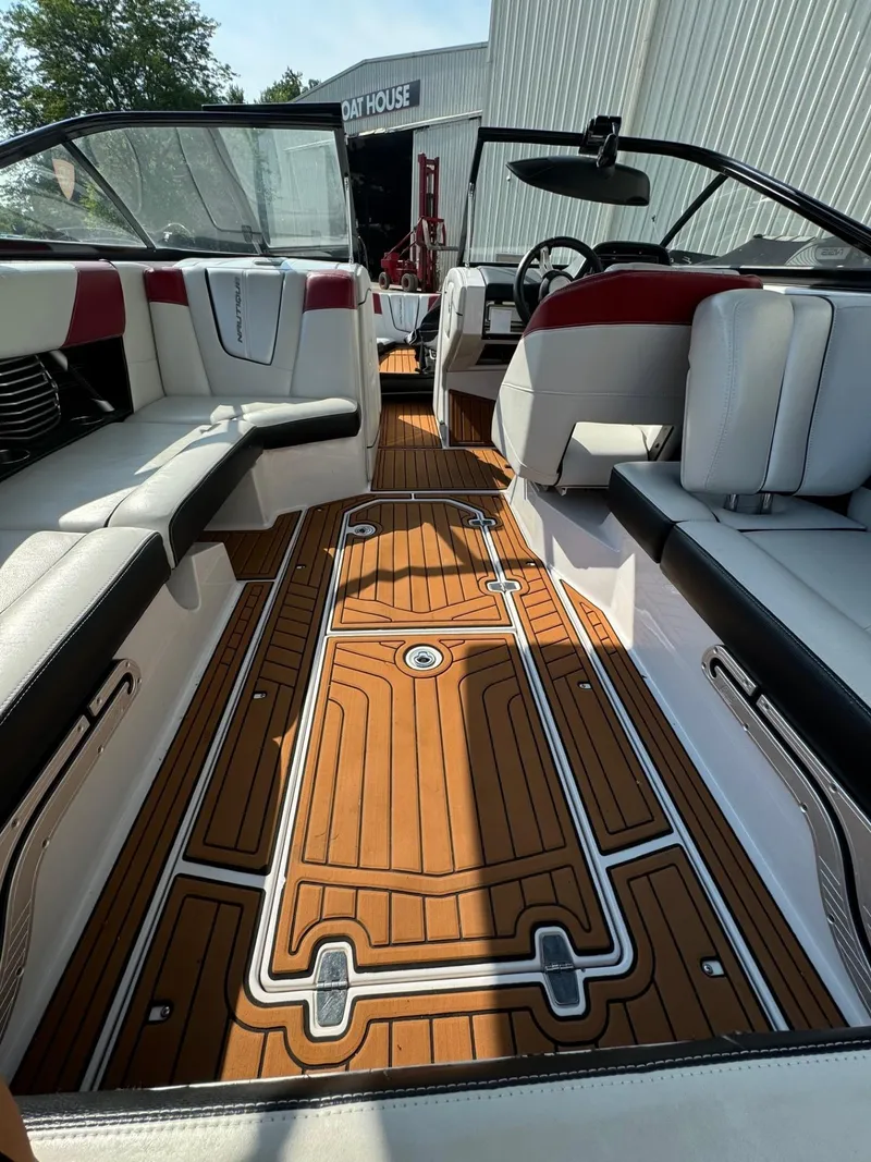 Slide: The Image of 2014 Nautique G23 boat interior with stylish seating and wood-patterned flooring. - 13