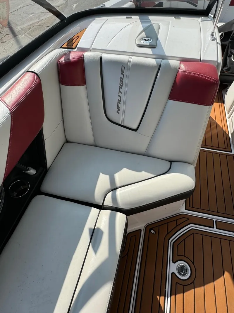 Slide: The Image of 2014 Nautique G23 boat interior with white and red seating, teak flooring. - 15