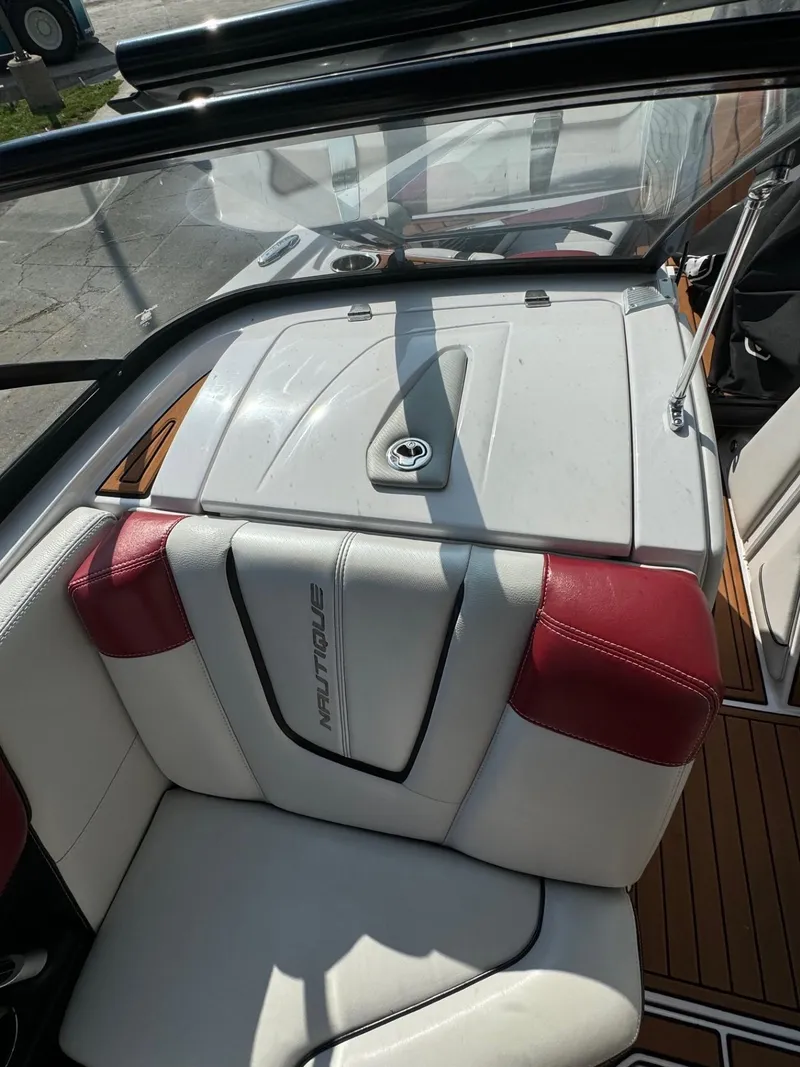 Slide: The Image of 2014 Nautique G23 boat interior with white and red seating. - 17