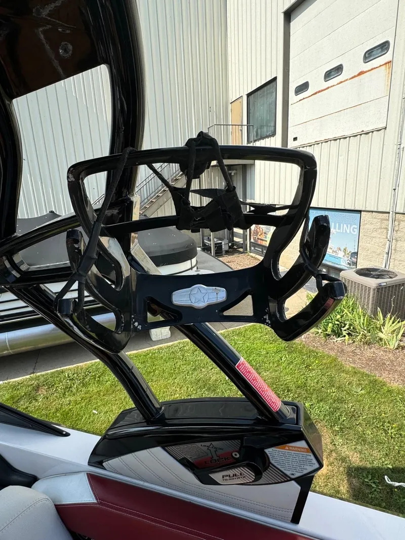 Slide: The Image of 2014 Nautique G23 wakeboard rack on a boat, near industrial building. - 26