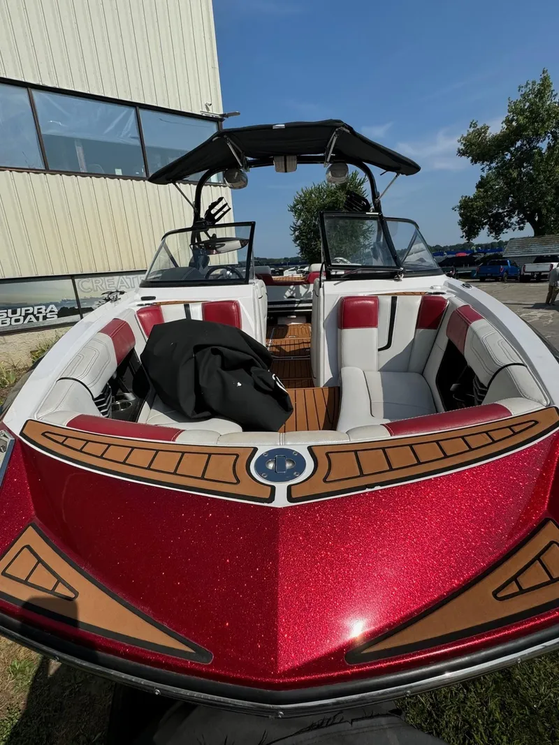 Slide: The Image of 2014 Nautique G23 boat with red and white interior, parked outdoors. - 4