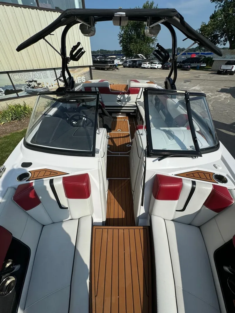 Slide: The Image of 2014 Nautique G23 boat interior with red and white seating, open windshield, and wooden flooring. - 5