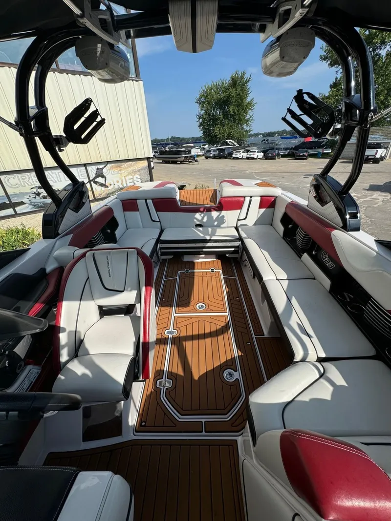 Slide: The Image of 2014 Nautique G23 boat interior with red and white seating, wooden flooring. - 6