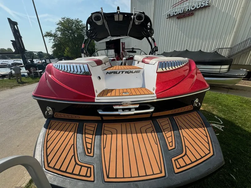 Slide: The Image of 2014 Nautique G23 boat with red and white design at a marina. - 8